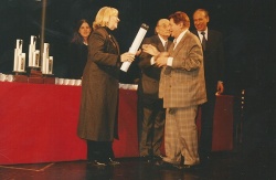  León Benarós, recibiendo de Olga Fernández Latour de Botas su premio "Kónex". Participan el historiador Félix Luna y por los organizadores el Sr. Osejevich (8-9-04)