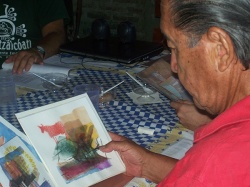Gallegos Quispe observando dibujos que fueron utilizados en la realización de la película "Hombre bebiendo luz", de Jorge Falcone