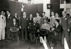 Orquesta de Francisco Canaro en Radio Carve (Montevideo, Uruguay). De izquierda a derecha el primero es Eduardo Adrián, el tercero Carlos Roldán, el cuarto Mariano Mores, el quinto Francisco Canaro. Abajo, de izquierda a derecha, el segundo es Minotto Di Cicco y el tercero Ernesto De Franco. Año 1942 (aprox.) .