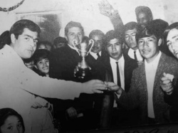 Sacerdote Juan Bertolone entregando un trofeo en un campeonato de fútbol barrial. (Foto del archivo de Miguel Albrecht)