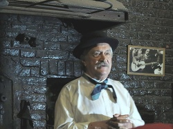 Héctor Del Valle hablando a la concurrencia que completó absolutamente la cuadra. Desde el cuadrito en la pared, también lo escucha Gabino Ezeiza.